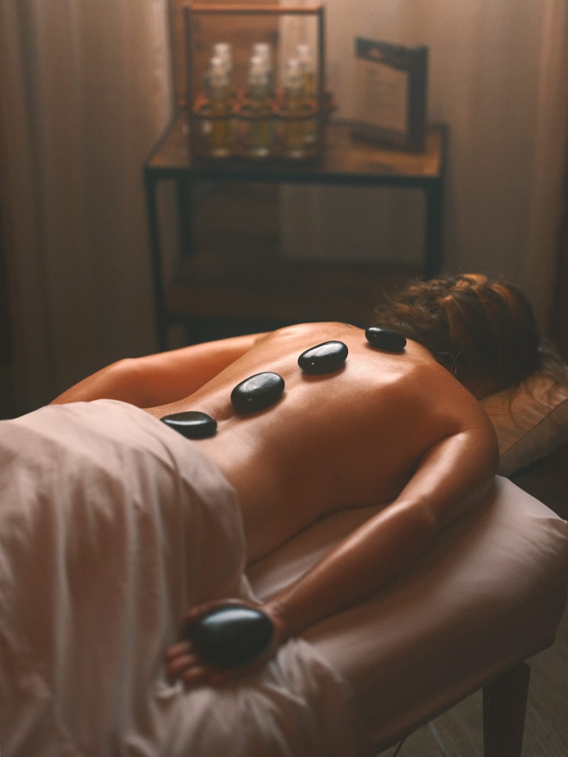 Hot basalt stones laid in a line down a client's back during a hot stone massage