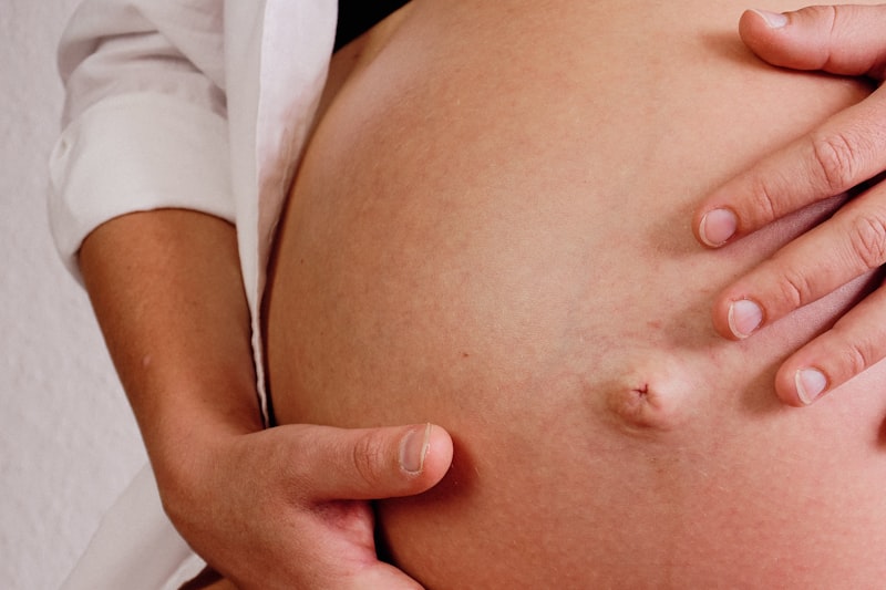 Gentle hands resting on a pregnant belly during a pregnancy massage